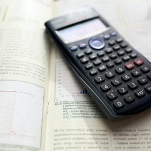 scientific calculator resting on open textbook