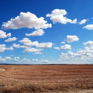 blue sky with clouds above a wide open field